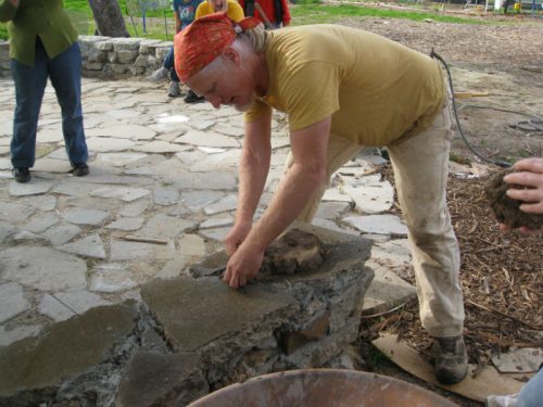 Wet the surface, slap a blob of cob mix down and mush it with your "cobber's thumbs"