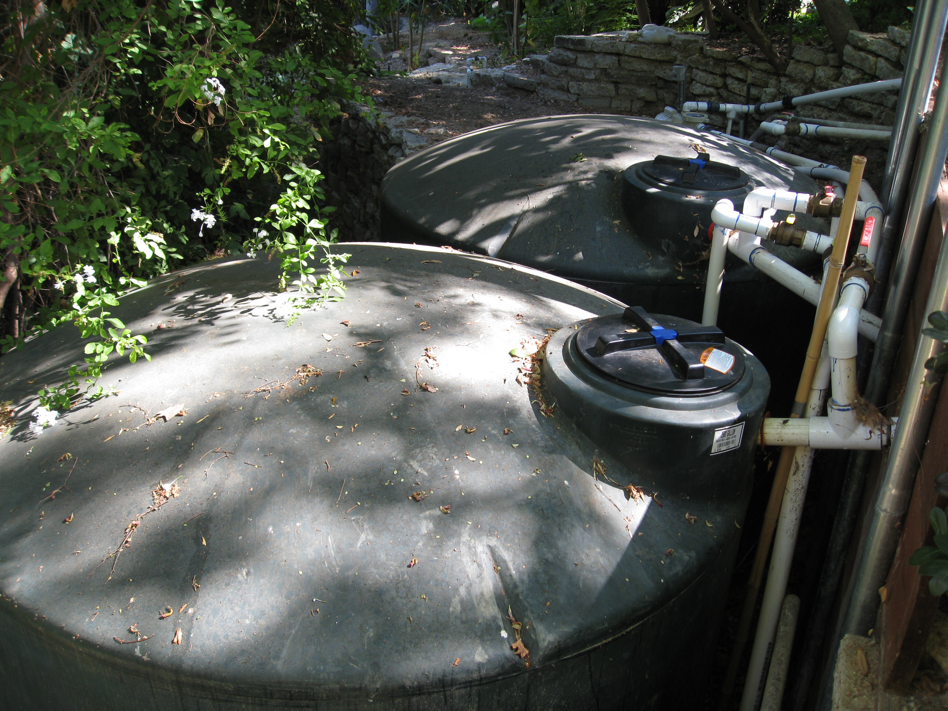 2 2,500 gallon tanks are nestled into the base of the hillside. 