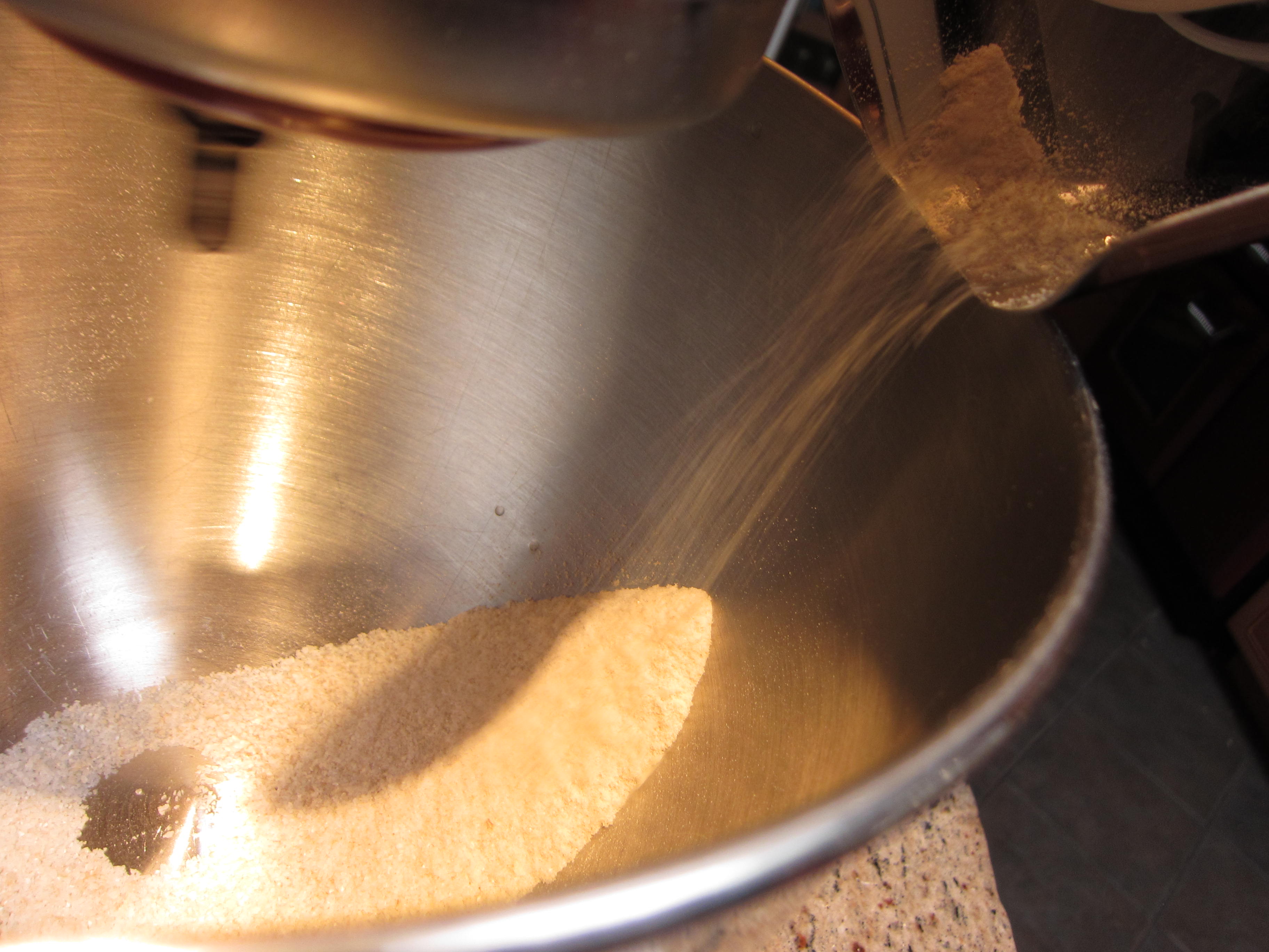 Rice flour pours from the mill down into the bowl. 